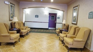 Classic lobby with armchairs, tables, and framed artwork.