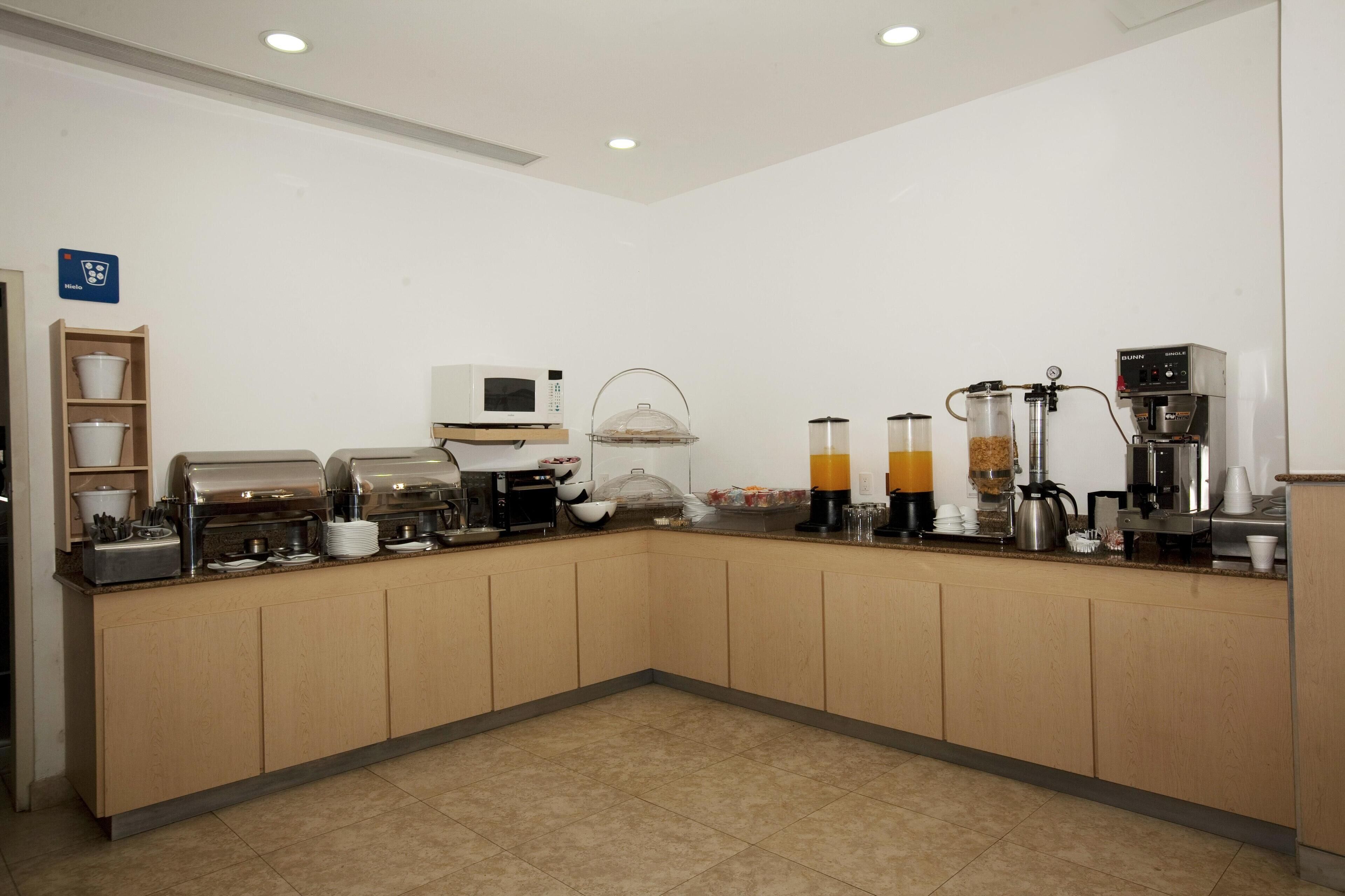 A clean, modern kitchen with a coffee station, microwave, and various appliances.