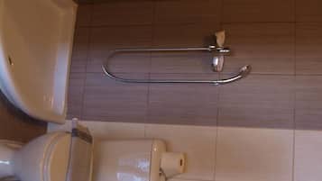 Ein Badezimmer mit Toilette, Bidet und Duschschlauch.