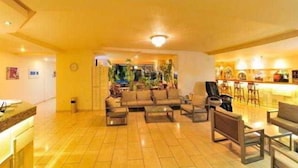 A spacious living area with a sofa set, coffee table, and a bar area with chairs. - Carina Hotel Rhodes (Rhodes)