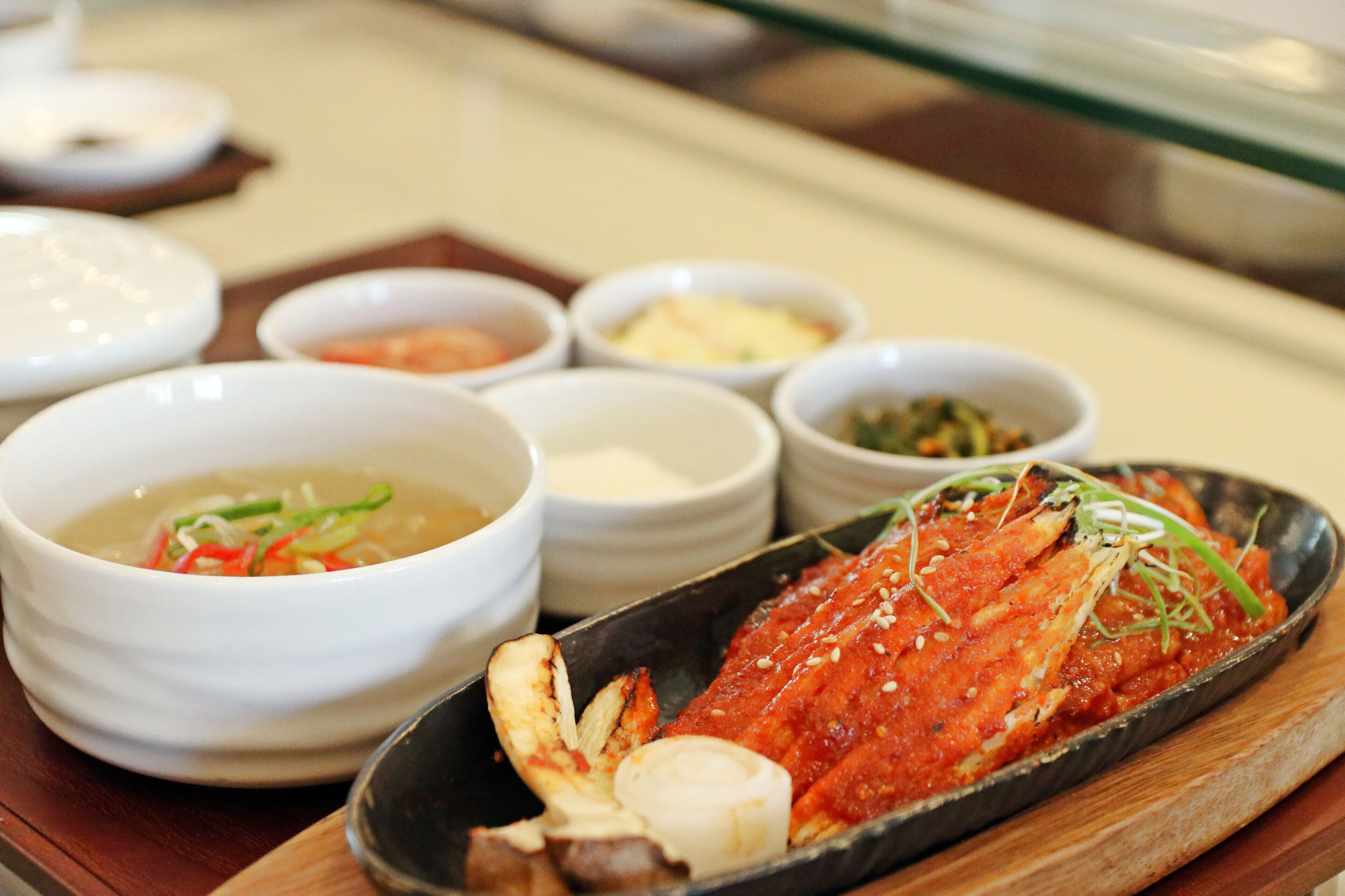 A seafood dish with various side dishes on a wooden table.