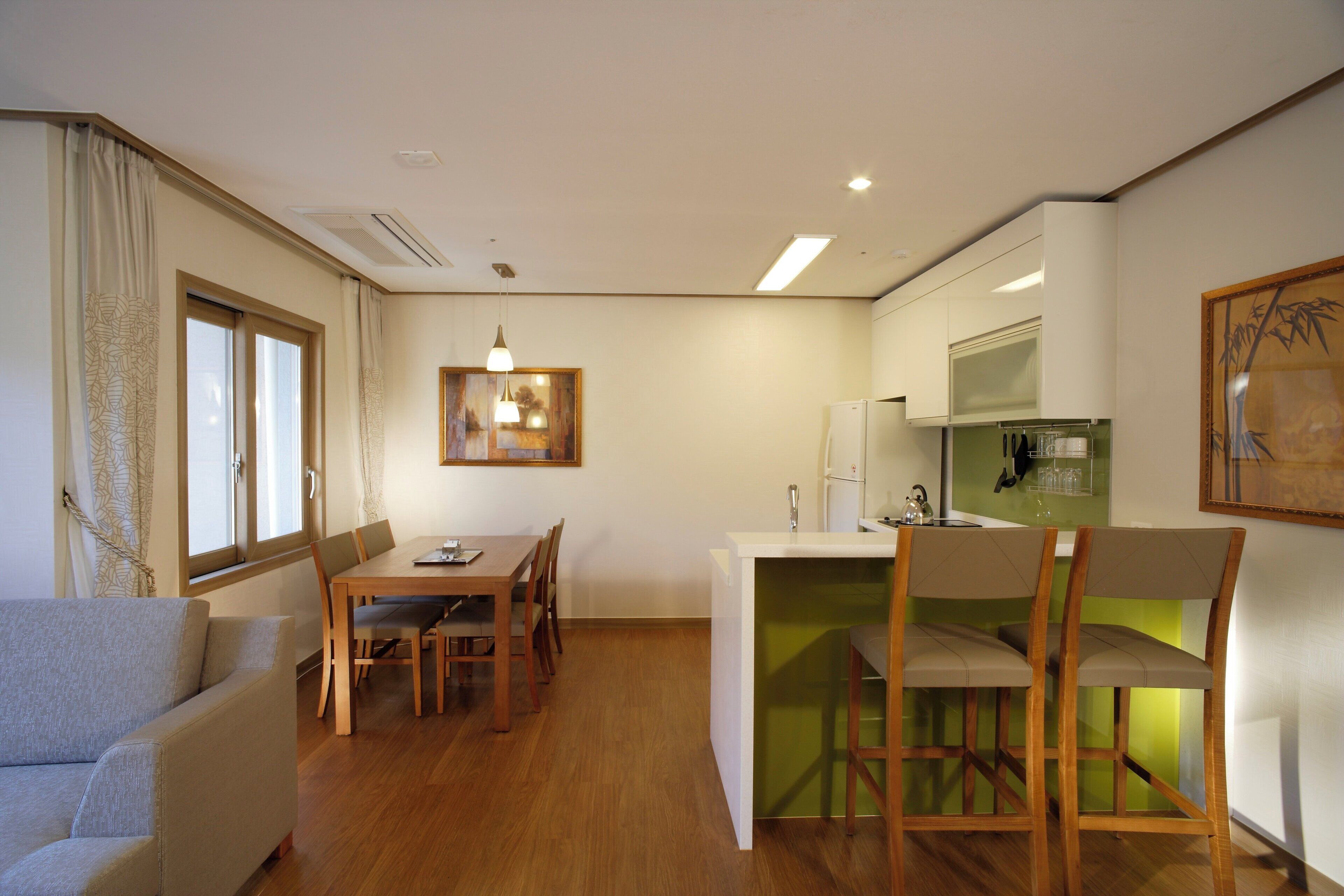 A compact living space with a dining area, kitchenette, and seating area.