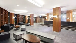 A modern lobby with seating areas, wooden shelving, and a reception desk. - Holiday Inn Alpensia Pyeongchang Suites by IHG (Pyeongchang)
