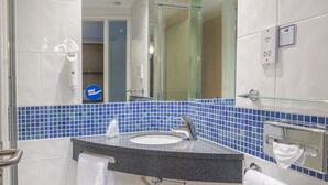 A modern bathroom with a large mirror, a sink, and a glass shower enclosure. - Holiday Inn Express Kettering by IHG (Kettering)