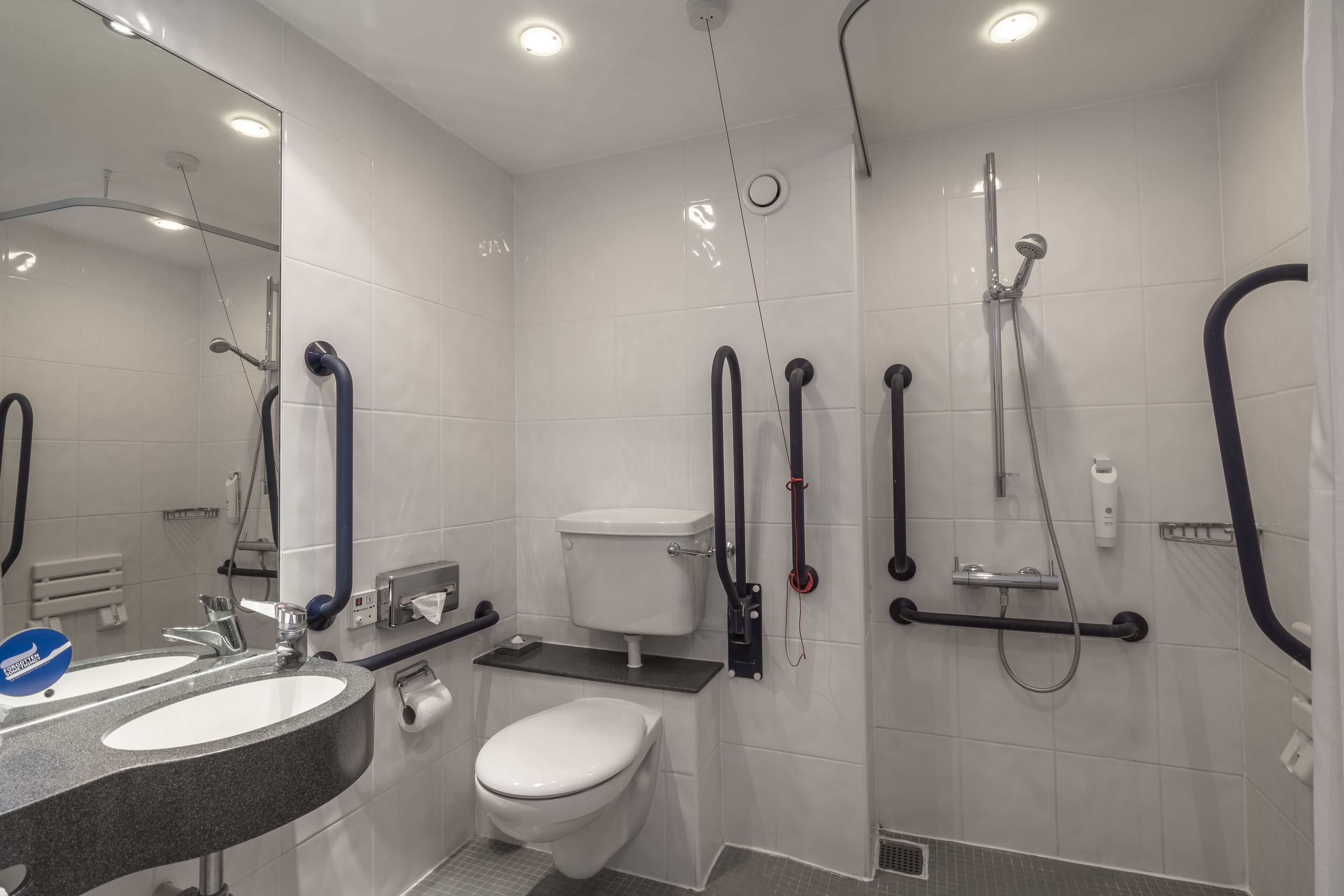 A modern bathroom with a toilet, sink, and shower.