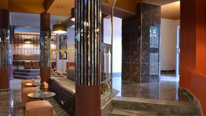 A lobby with a seating area, a staircase, and a reception desk.