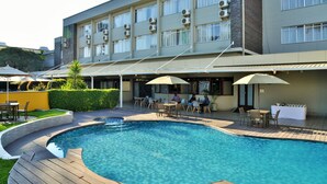 A swimming pool with wooden decking and outdoor seating.