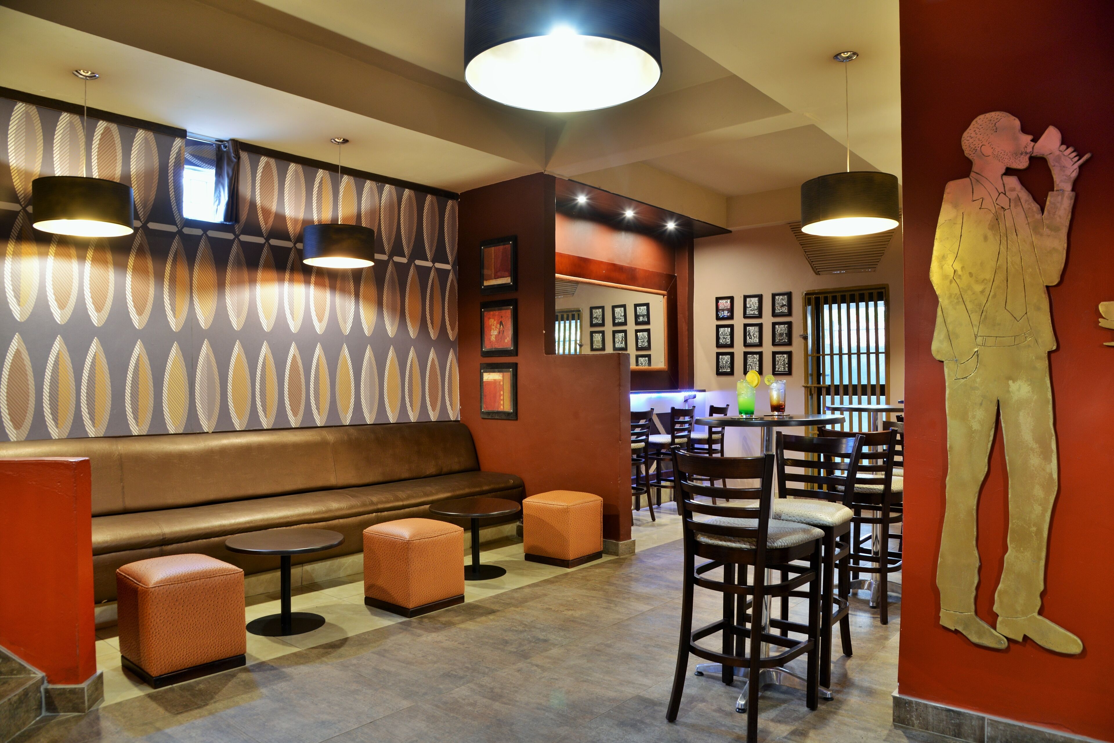 Un restaurante con una zona de asientos tipo cabina, mesas redondas y sillas.