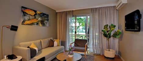 Una sala de estar moderna con un sofá, un sillón, una mesa de centro y un cuadro grande en la pared.