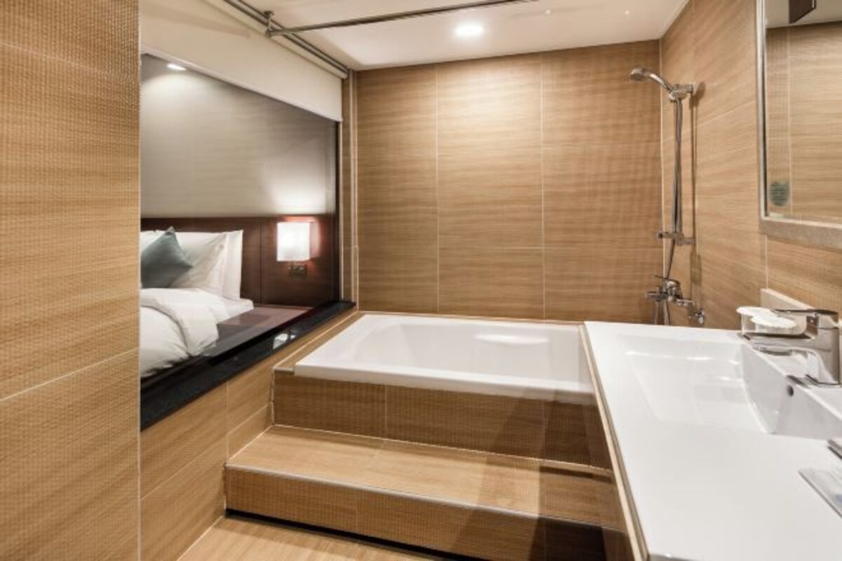 Un baño moderno con una bañera grande, zona de ducha y tocador con espejo.