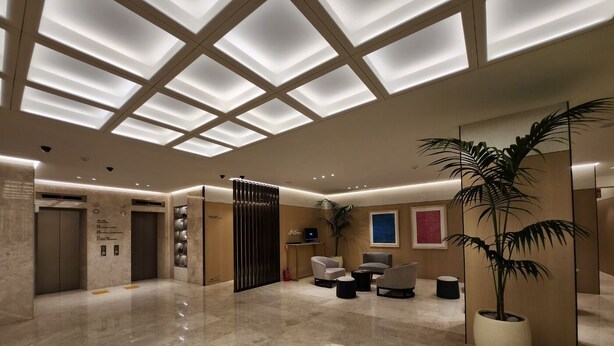 A modern lobby with a glass ceiling, a reception desk, seating area, and a large potted plant. - Hotel Sunshine Seoul (Seoul)