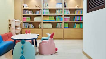 A children's play area with colorful furniture and a bookshelf filled with books.