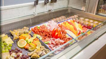 Un présentoir de charcuterie proposant une variété de viandes, de fromages et de fruits.