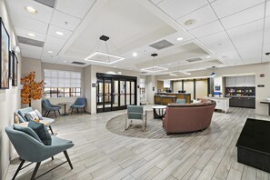 A hotel lobby with seating areas, a reception desk, and a kitchenette. - Homewood Suites by Hilton Lancaster (Lancaster)