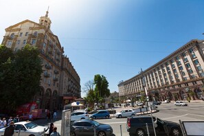 A busy urban street with historic buildings, a roundabout, and various vehicles. - KievApartment (Kyiv)