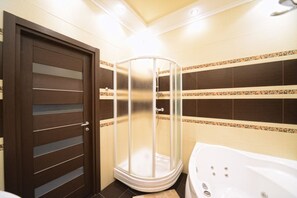 A bathroom with a shower enclosure, a bathtub, and a door with horizontal lines. - KievApartment (Kyiv)
