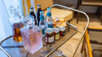 Una mesa de vidrio con varios frascos y botellas, incluyendo un decantador de vidrio rosa y varias botellas con tapones azules.