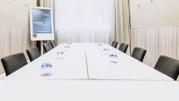A conference room with a long table, chairs, and a banner.