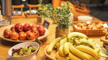A table with various fruits including apples, bananas, and oranges.