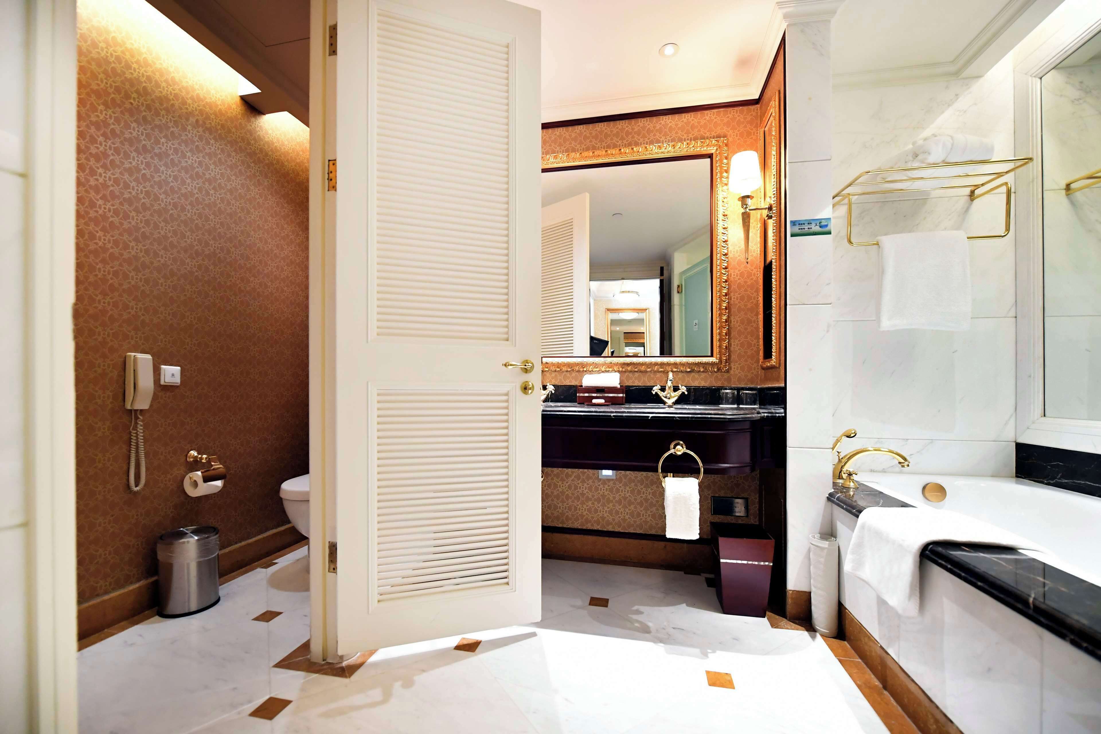 A bathroom with a toilet, bidet, sink, and bathtub.