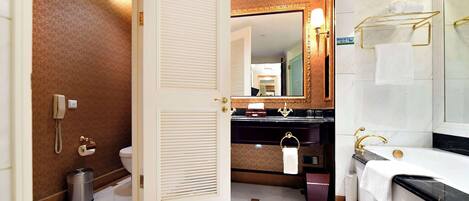 A bathroom with a toilet, bidet, sink, and bathtub.