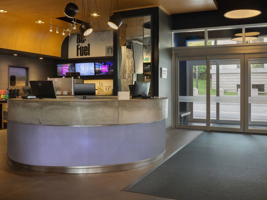 A reception desk with a computer, a monitor, and a menu board.