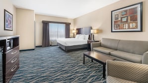 A hotel room with a bed, a sofa, a desk, and a dresser. - Best Western Plus Eastgate Inn & Suites (Wichita)