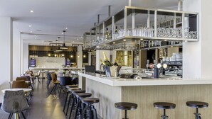 A modern bar area with stools, a counter, and shelves with glasses and bottles. - Best Western Plus Europe Hotel (Brest)