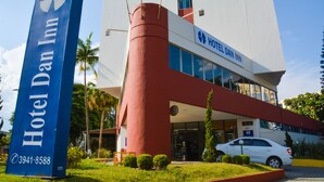 Un hôtel Dan Inn reconnaissable à son grand panneau bleu, à sa structure cylindrique rouge et à sa façade blanche.