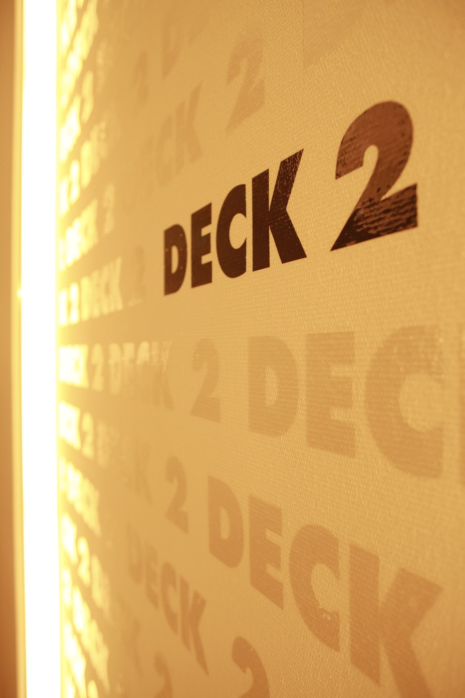 A wall with repeated text 'DECK 2' indicating a specific area or room.