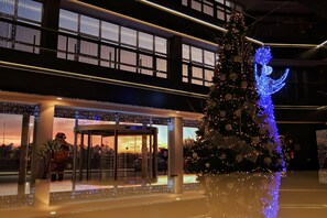Entrada de hotel con un árbol de Navidad decorado con luces y adornos.