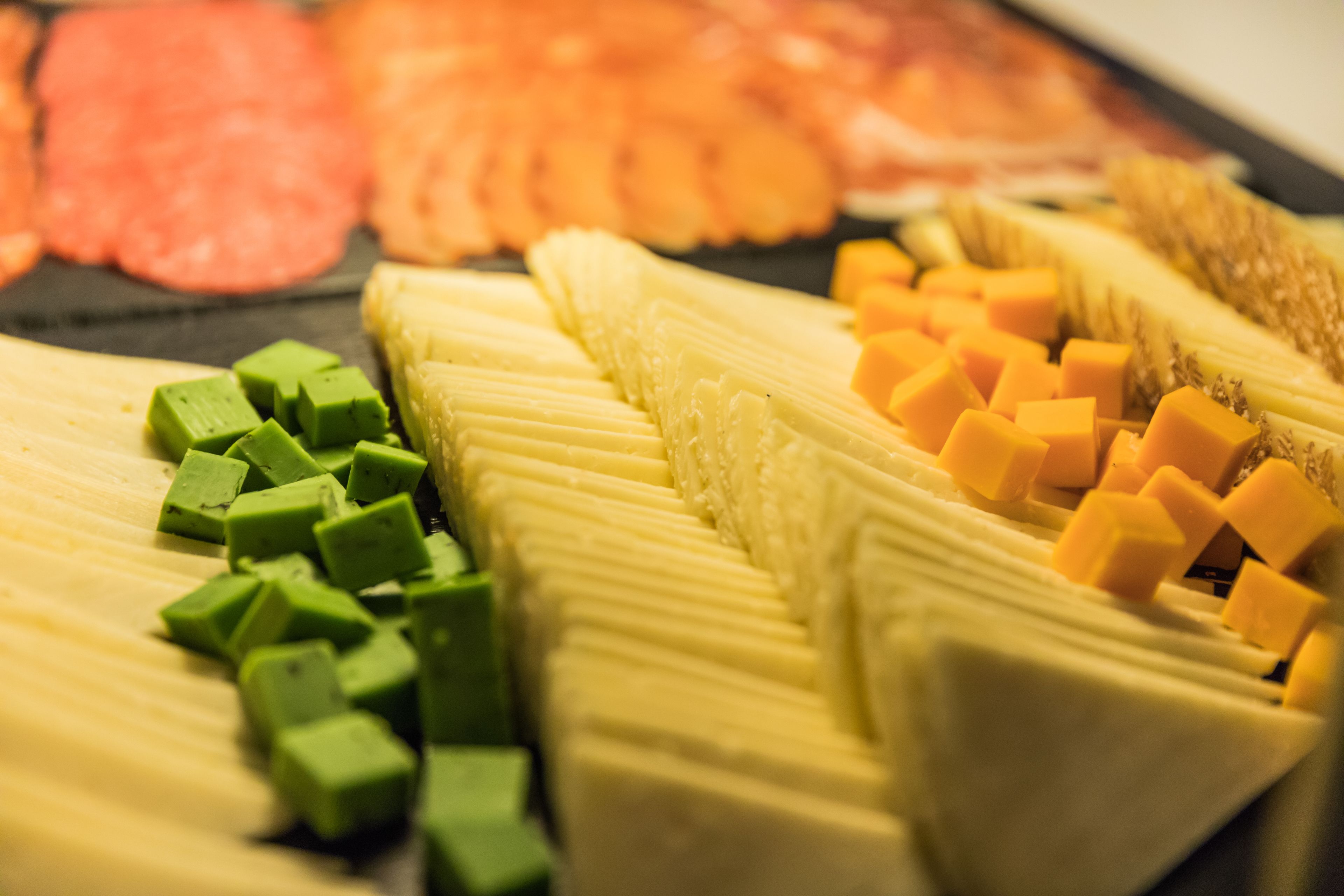 Une variété d'aliments, notamment des viandes en tranches, du fromage et des légumes, disposés sur un plateau.