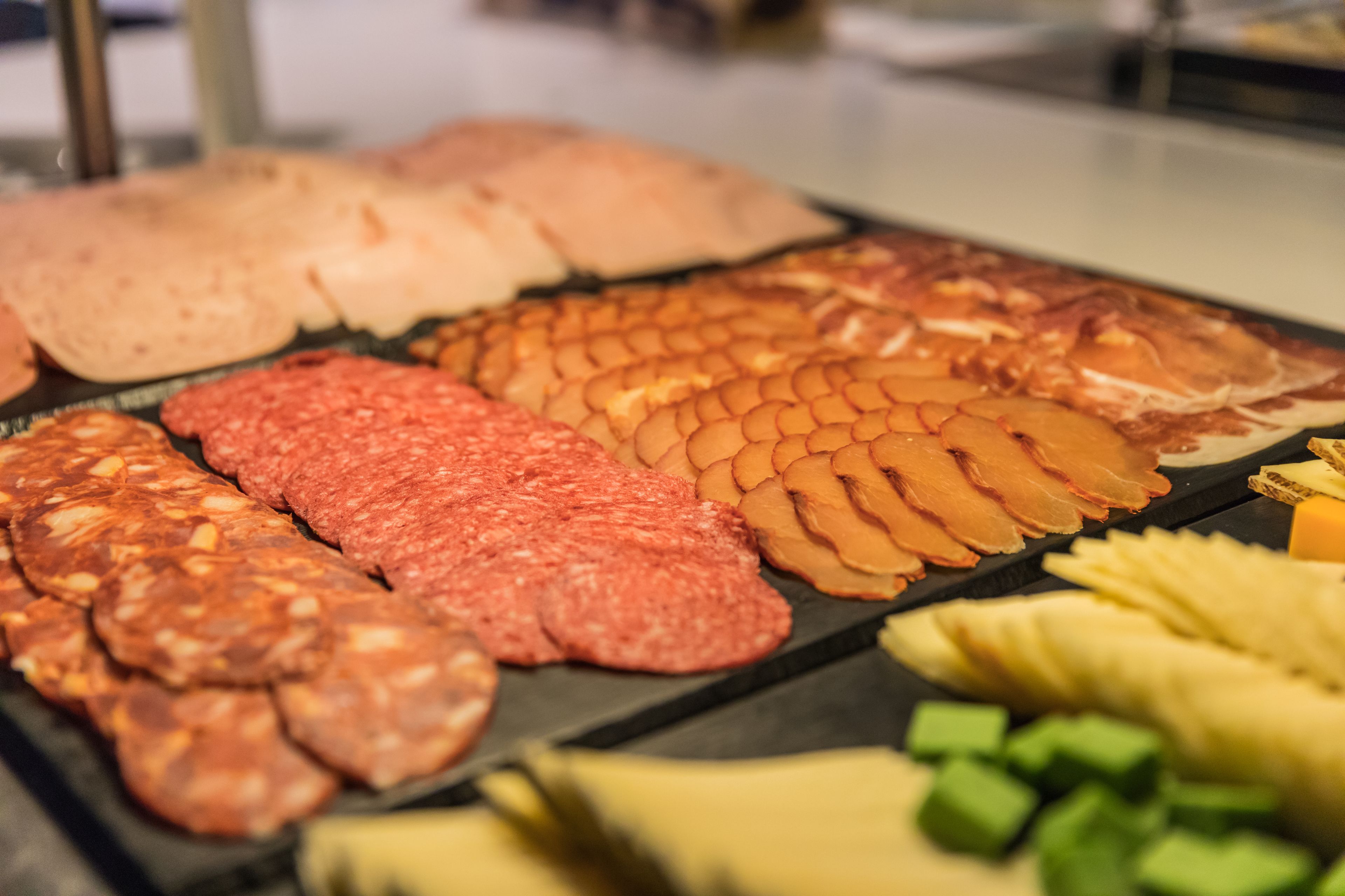 A variety of meats and cheeses on a display.