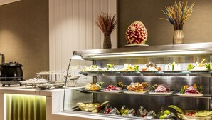 Un bufé con diversos alimentos y una decoración central.