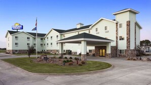 Un hôtel Days Inn & Suites doté d’une entrée centrale, d’un patio couvert et d’un espace extérieur aménagé.