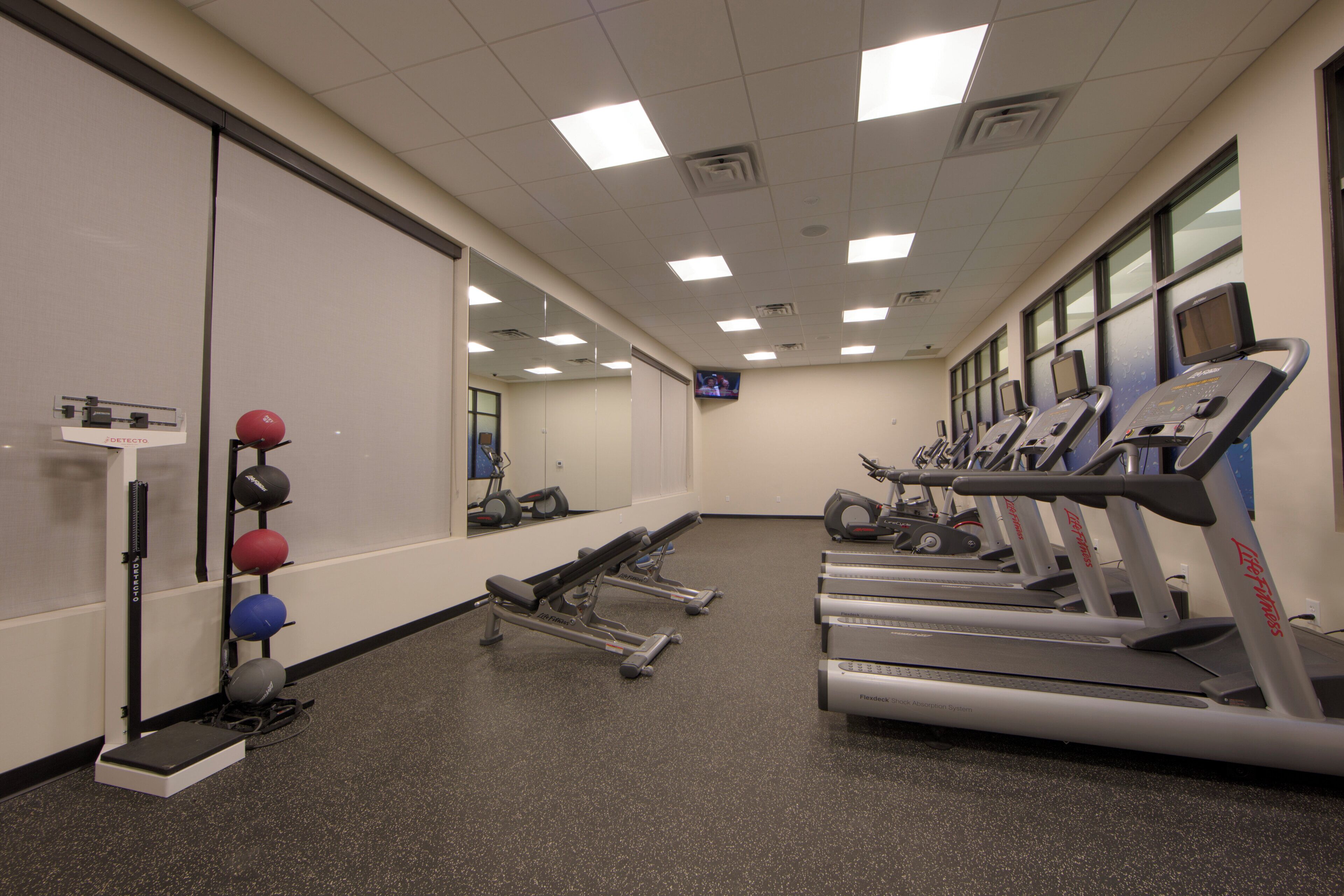 A gym with treadmills, exercise balls, and weight machines.