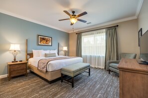 A hotel room with a bed, a desk, a chair, a ceiling fan, and a window with curtains. - Holiday Inn Club Vacations Williamsburg Resort by IHG (Williamsburg)