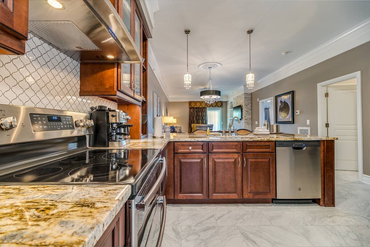 A modern kitchen with granite countertops, stainless steel appliances, and wooden cabinets.