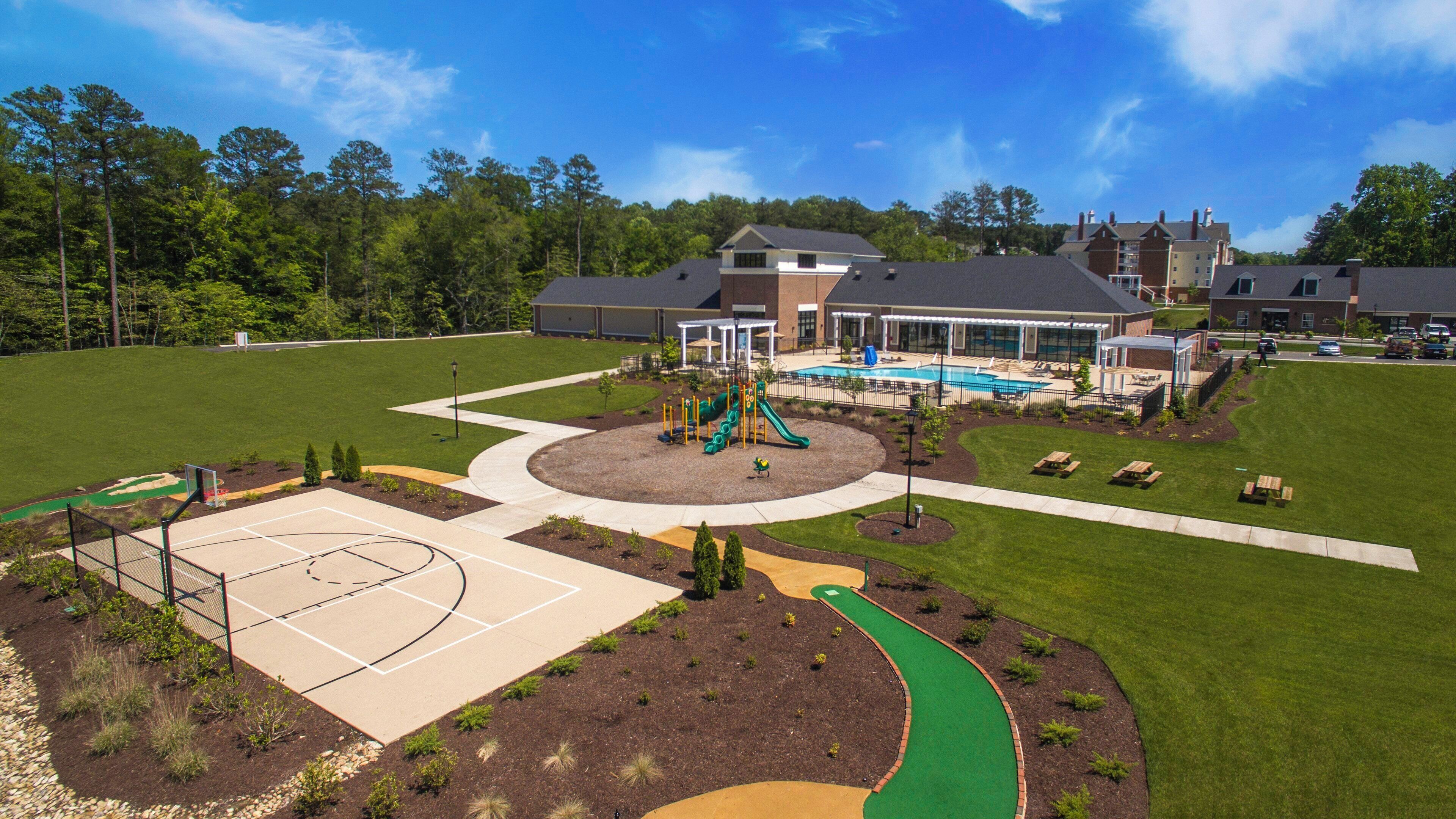 A playground with a basketball court, a pool, and a covered seating area.