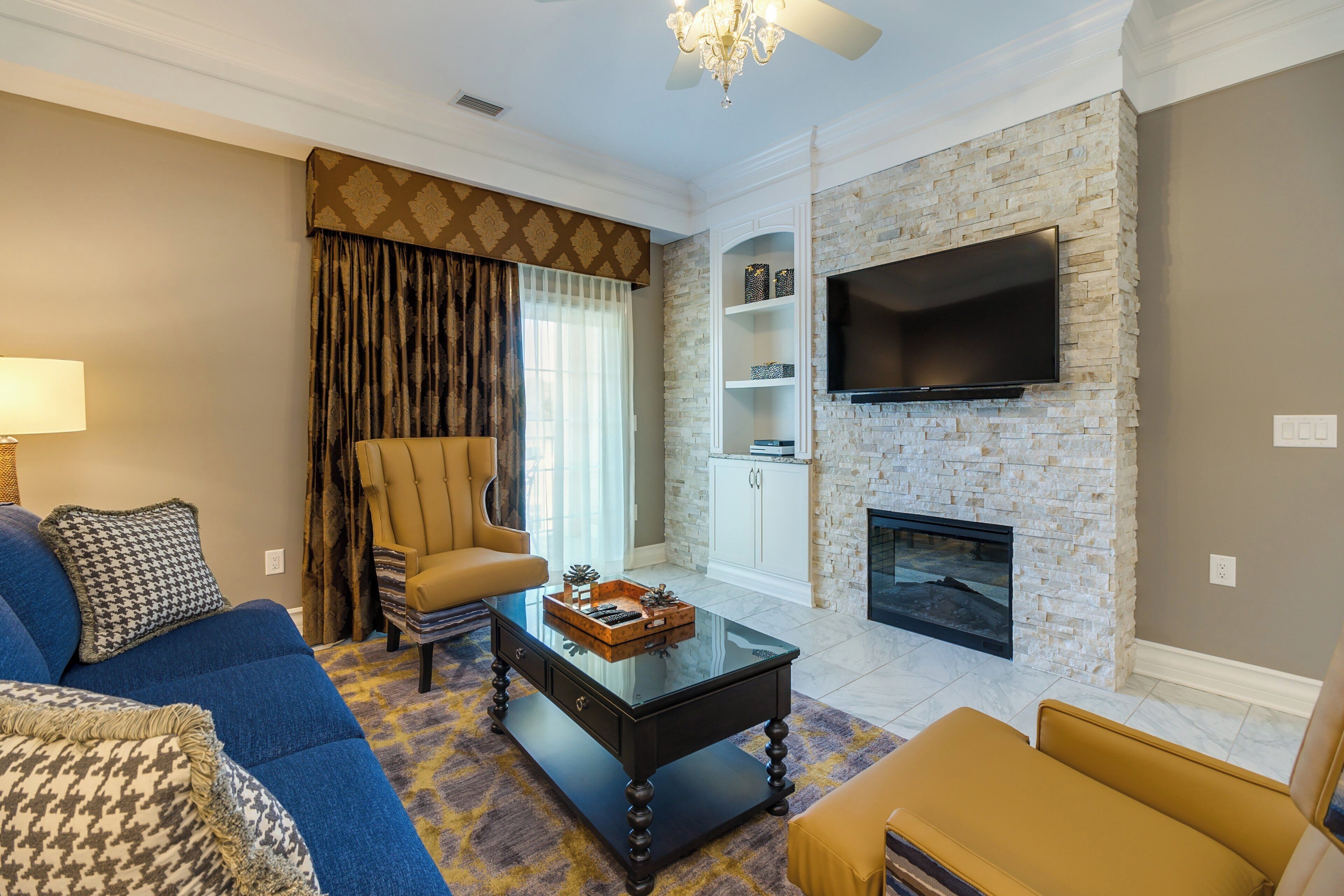 A living room with a sofa, armchair, coffee table, and a fireplace.