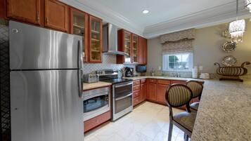 A kitchen with stainless steel appliances, wooden cabinets, and a granite countertop.