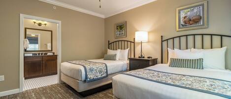 A hotel room with two beds, a bathroom, and a ceiling fan.