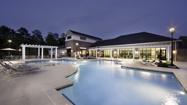 A swimming pool with lounge chairs and a covered area, surrounded by a building with large windows and a brick facade. - Holiday Inn Club Vacations Williamsburg Resort by IHG (Williamsburg)