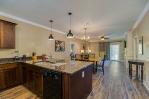 A kitchen with granite countertops, a dishwasher, and a dining area with a table and chairs. - Holiday Inn Club Vacations Williamsburg Resort by IHG (Williamsburg)