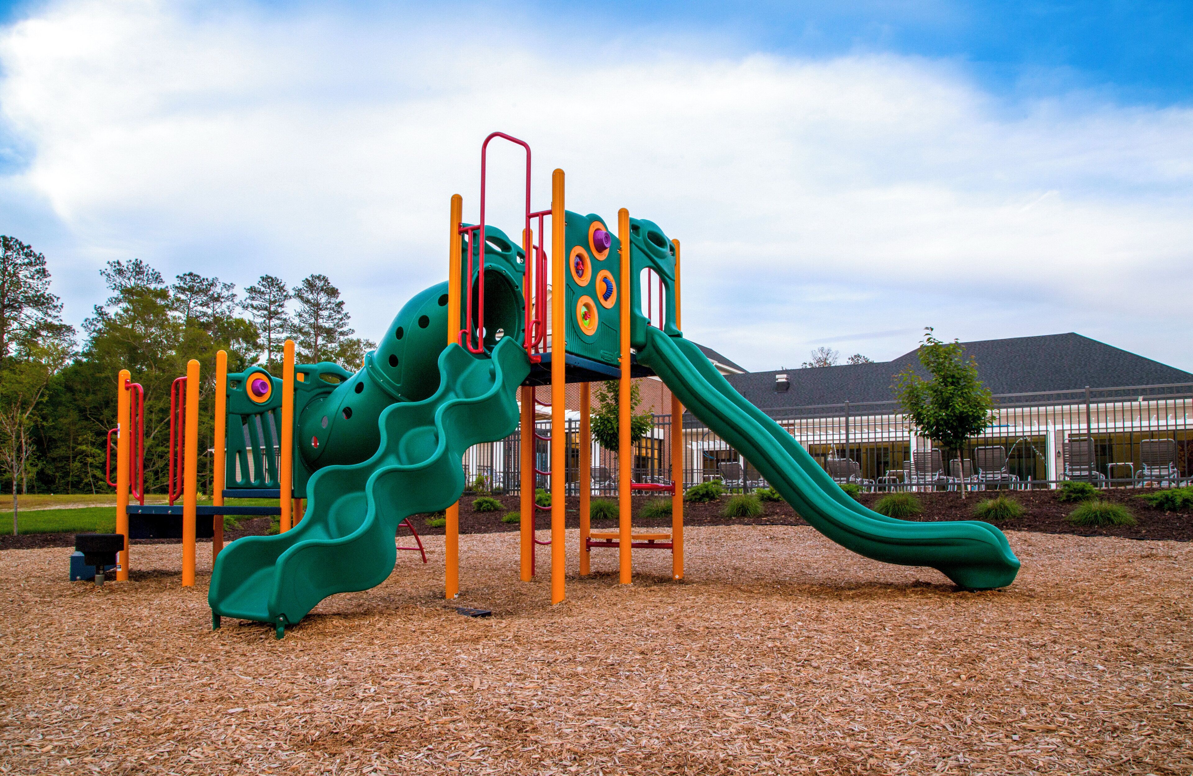 A playground with a slide and climbing structures.