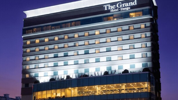 A multi-story hotel with a prominent sign reading 'The Grand Hotel - Daegu.' - Grand Hotel (Daegu)
