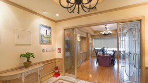 A hotel lobby with a marble floor, a dining area with a bar, and a chandelier. - Libero Hotel (Busan)