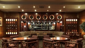 A bar area with round mirrors, a bar counter, and seating. - Hotel Paragon (Busan)