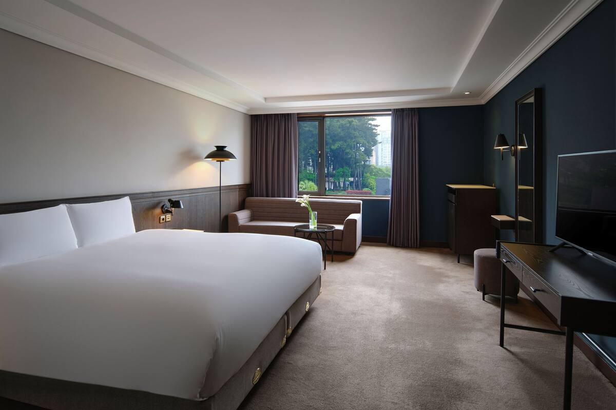 Een hotelkamer met een groot bed, een bureau, een stoel en een televisie.