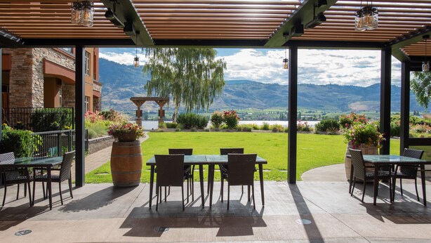 Une terrasse extérieure offrant une vue sur les montagnes et un lac.